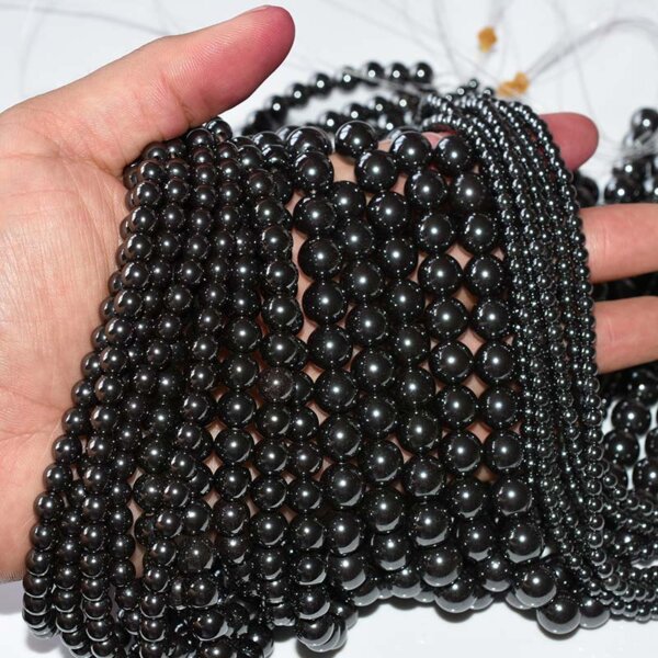 Bulk Hematite Beads for Jewelry Making held in hand, glossy black finish