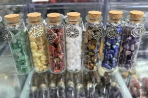Healing stones in glass bottles with crystal chips and chakra charms for spiritual energy
