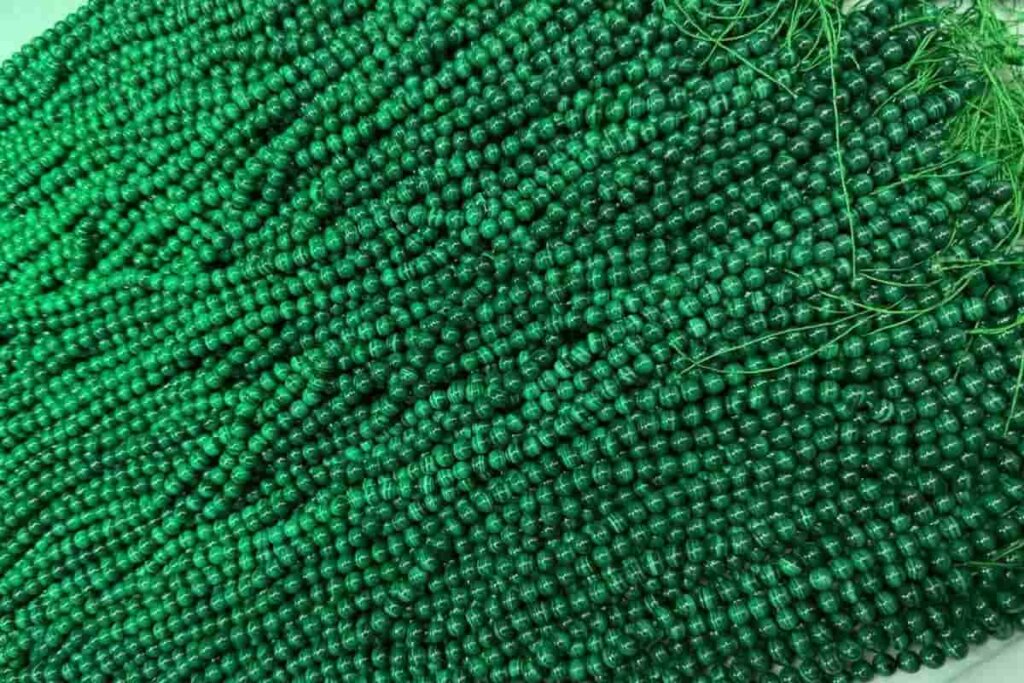 8mm Malachite strand beads showcasing vibrant green patterns, popular for jewelry making and known for Malachite benefits like emotional healing and protection.