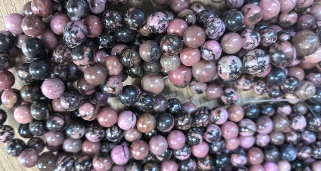 Natural strand comparison: rhodonite vs rhodochrosite bead