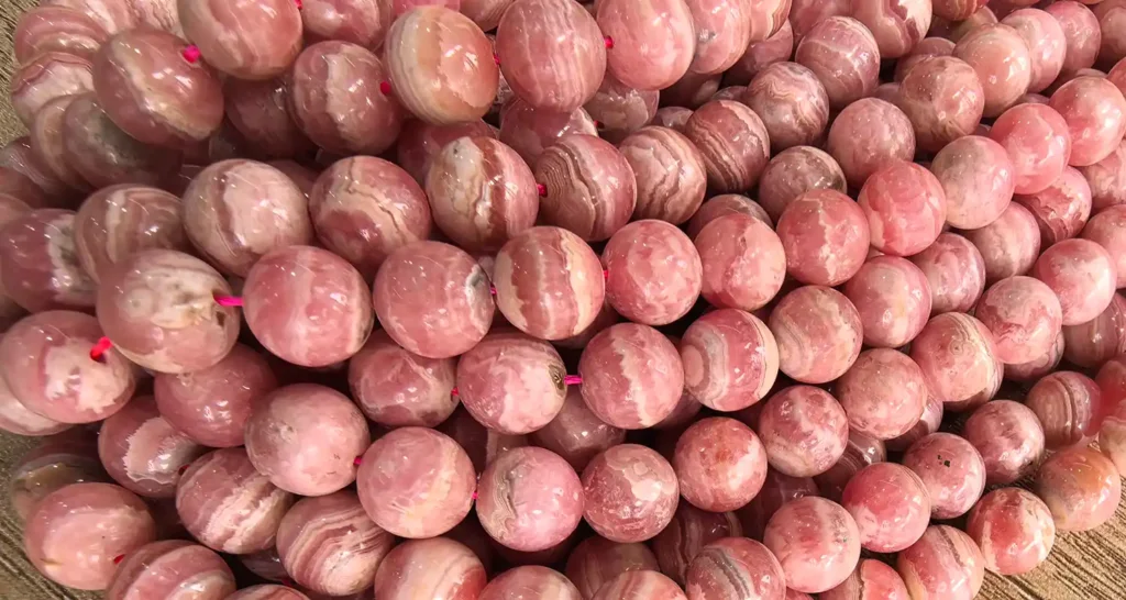 Rhodonite vs rhodochrosite beads close-up for jewelry making