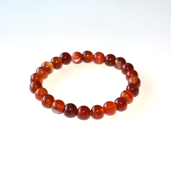 Carnelian bracelet close-up on white background, red-orange gemstone beads