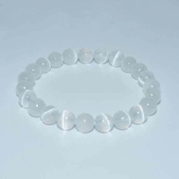 Elastic round white selenite bead bracelet on white background