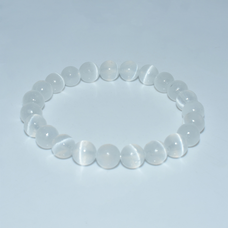 Elastic round white selenite bead bracelet on white background