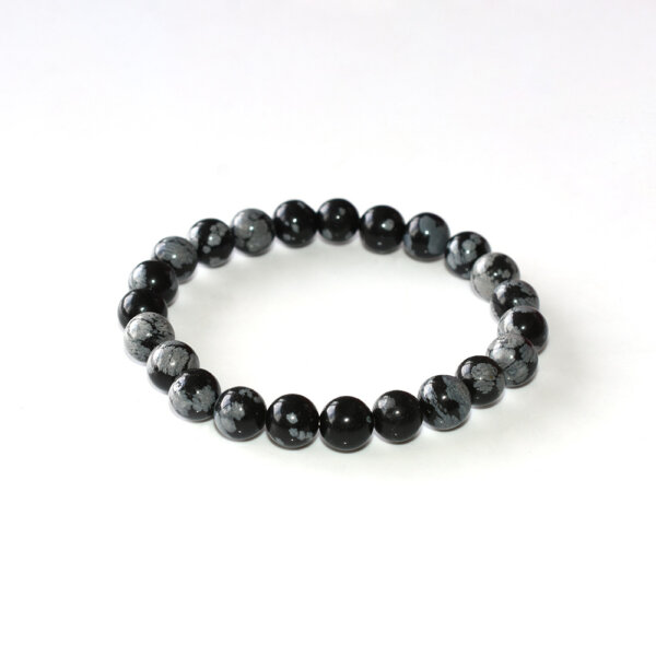 Snowflake Obsidian bracelet with black and white marbled beads on white background, ideal for spiritual grounding.