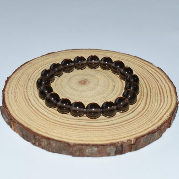 Crystal Healing Smoky Quartz Bracelet placed on wooden stand for product showcase