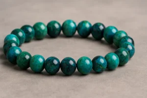 Polished Chrysocolla Bracelet with vibrant blue-green beads on a neutral background