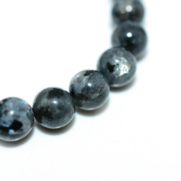 Close-up of Larvikite crystal beads with visible shimmer and texture