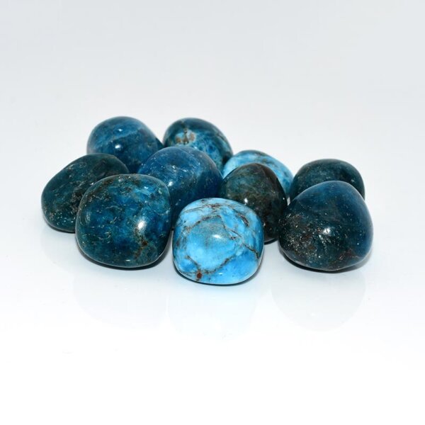 Cluster of glossy blue apatite tumbled stones on white background