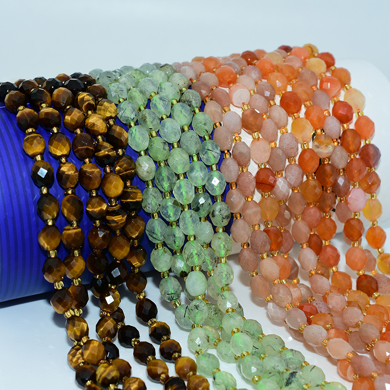 Faceted rice beads in mixed gemstone colors, including tiger eye, green aventurine, and carnelian, displayed in strands