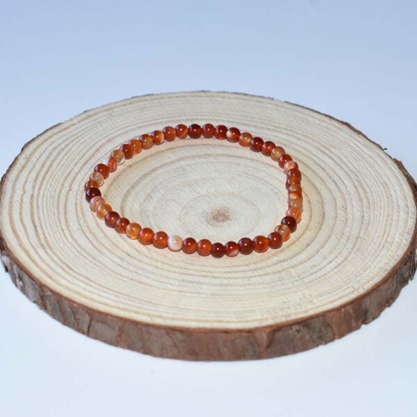 Thin carnelian beaded bracelet with translucent orange-red tones