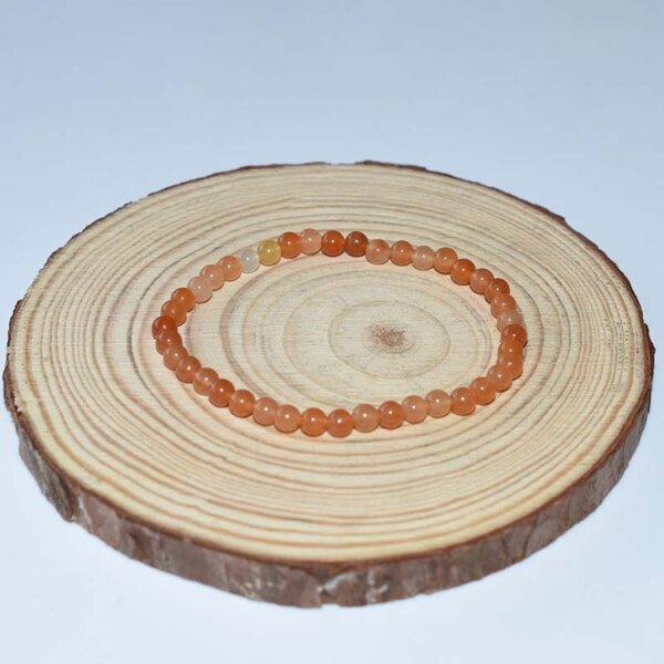 Orange-toned Red Aventurine Bracelet displayed on wood tray