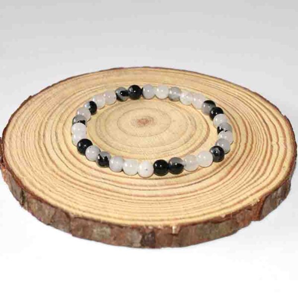 Evenly spaced Black Rutilated Quartz bracelet laid flat on wooden surface
