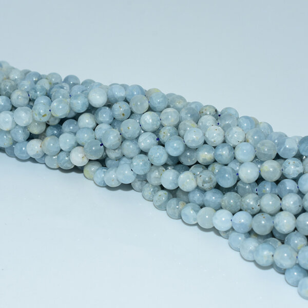 Diagonal view of celestite beads strand showing uniform shape and delicate color