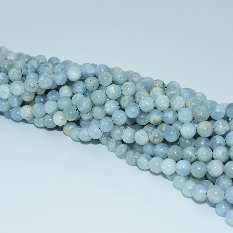 Diagonal view of celestite beads strand showing uniform shape and delicate color