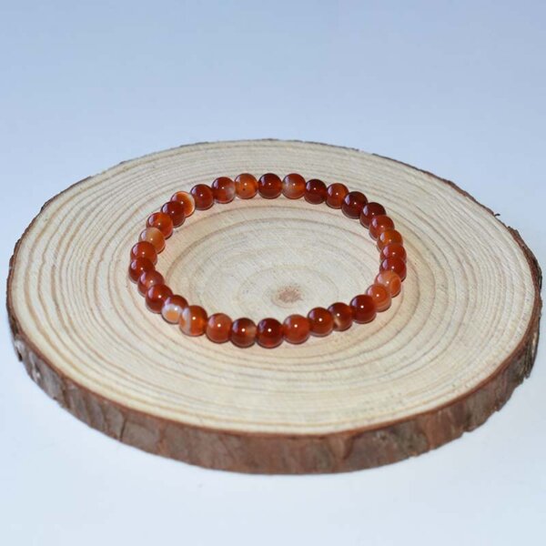 Small carnelian bracelet on wooden textured background