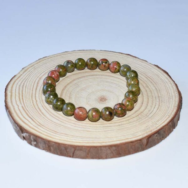 8mm Unakite Bracelet placed on wooden display board, emphasizing green-pink stone blend.