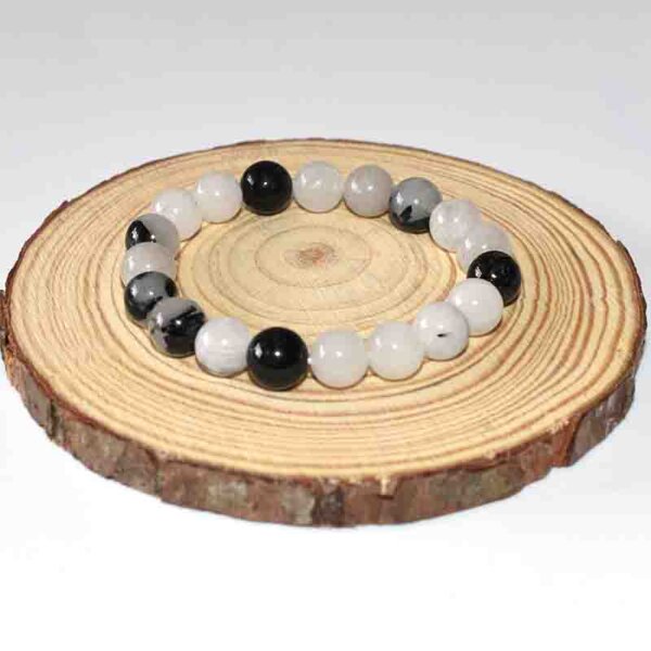Black Rutilated Quartz bracelet with mixed bead tones on round wood base
