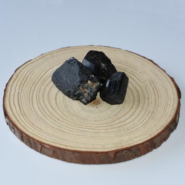 Raw Black Tourmaline cluster arranged on a circular wood slab 2-3cm