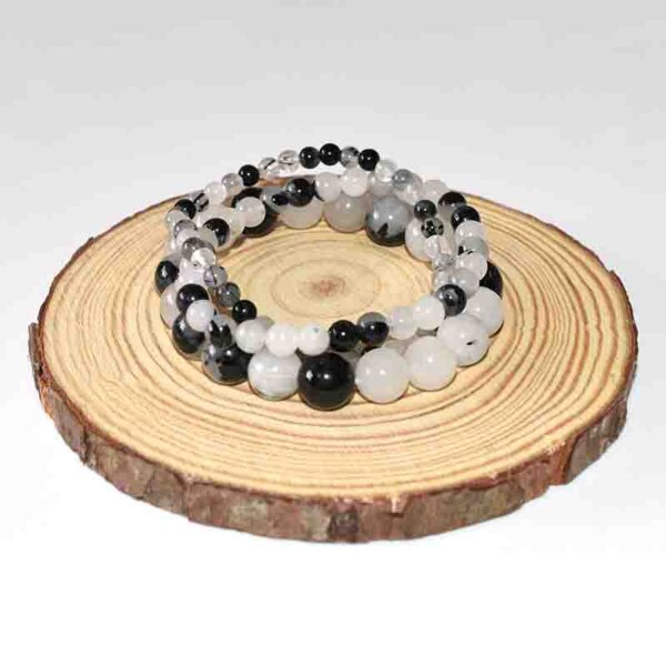 Double strand Black Rutilated Quartz bracelet placed on wooden slice