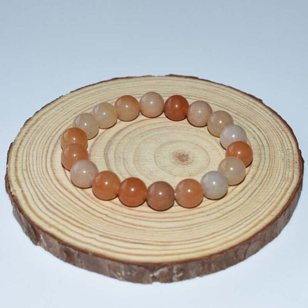 Red Aventurine Bracelet with deep red beads on wooden display