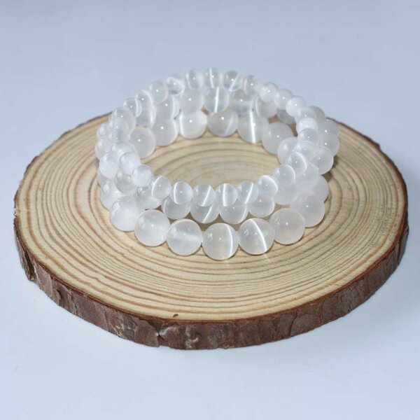 White selenite chip bracelet displayed on wooden base