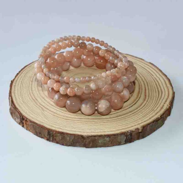 Double Sunstone Crystal Bracelets displayed on wooden board, warm-toned healing stone design