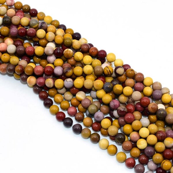 Loose Mookaite Jasper beads showing natural red, yellow, and cream colors