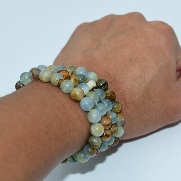Person wearing Blue Calcite Bracelet on wrist, showing natural gemstone colors