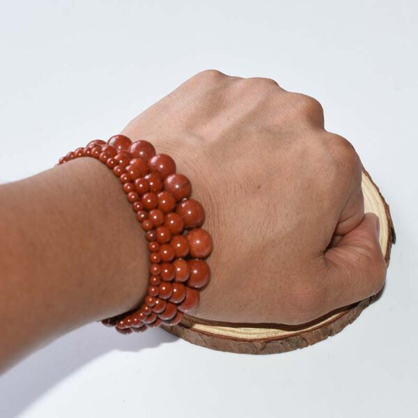 Red Jasper bracelets stacked on wrist, showcasing layered style and vibrant red gemstone energy.