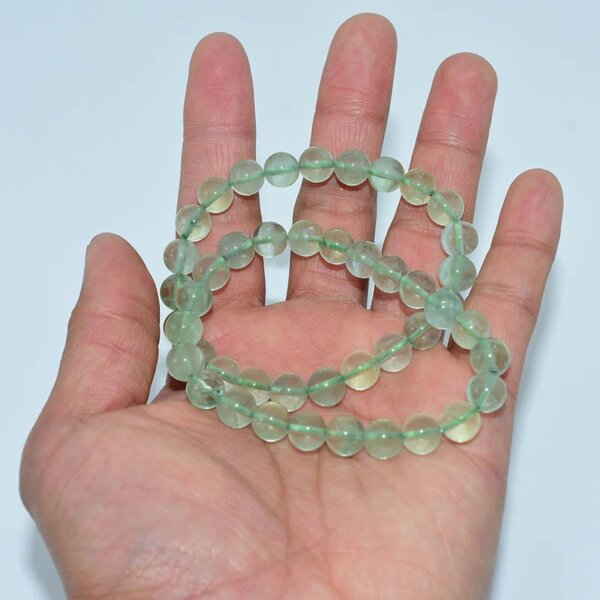 Hand holding multiple Green Fluorite Bracelets – natural gemstone beads