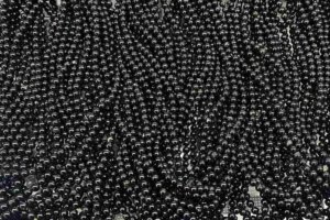 8mm Black Tourmaline strand beads showing polished surface and natural texture, symbolizing grounding and protection related to Black Tourmaline meaning.