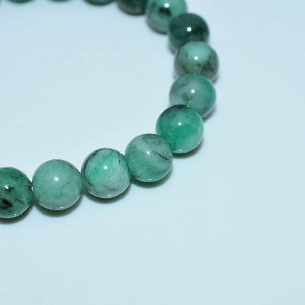Close-up shot of emerald beads showing polish and natural inclusions