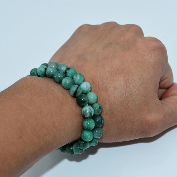 Side view of emerald bracelet on wrist displaying round bead texture