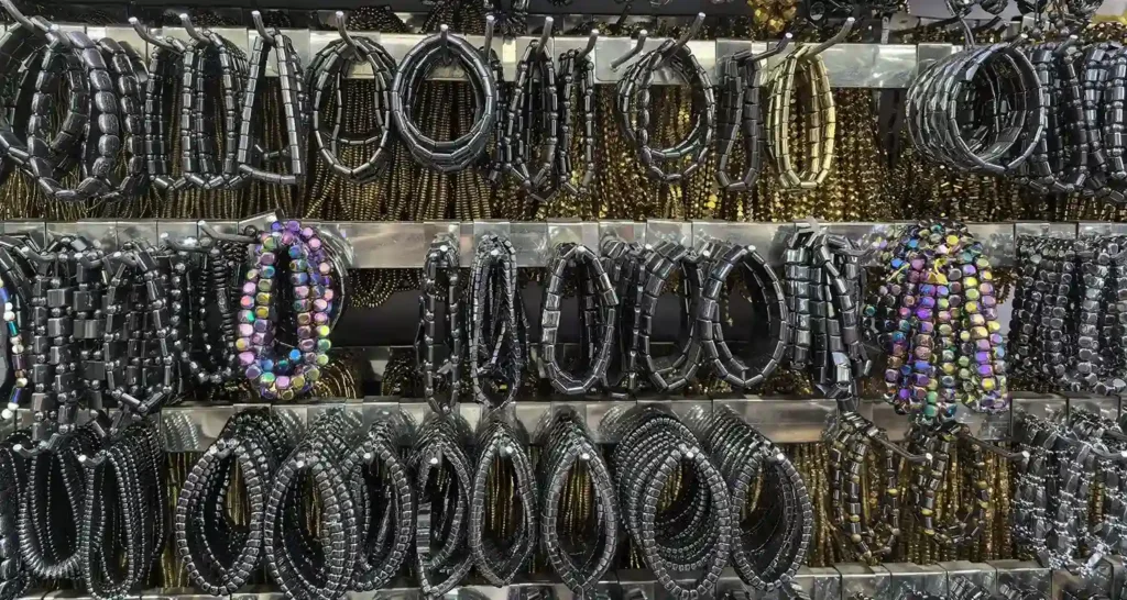 Display of multiple hematite bracelets on a shop wall, highlighting the variety and accessibility of hematite bracelet benefits.