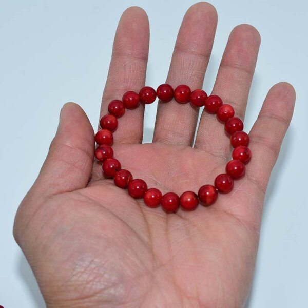 Hand holding a Red Coral Bracelet – authentic red gemstone accessory