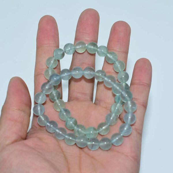 Hand holding multiple Blue Fluorite Bracelets for size comparison
