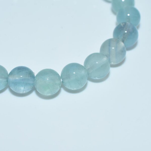 Close-up view of blue fluorite crystal beads showing natural clarity