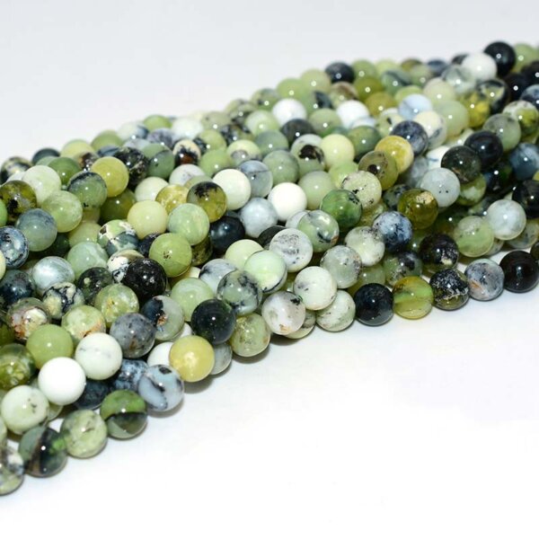 Close-up of bulk Green Opal Beads with natural green and cream hues