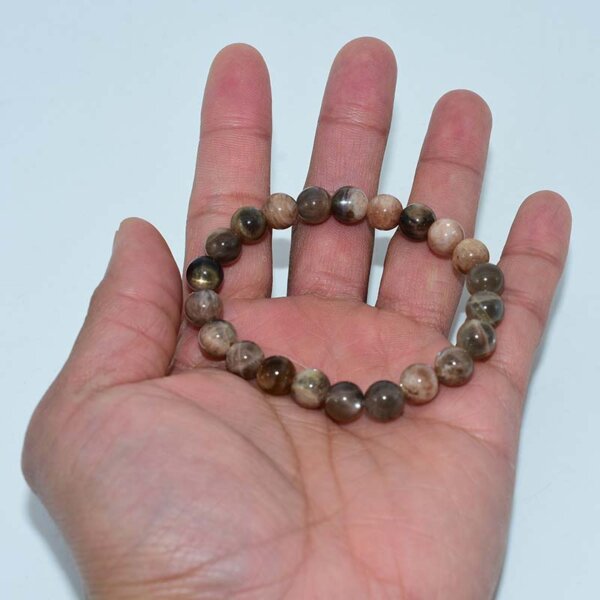 Hand holding Black Sunstone Bracelet to show bead size and design