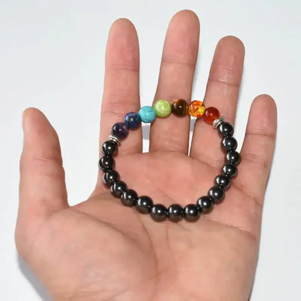 Hand holding Hematite Chakra Bracelet with root-to-crown gemstone accents