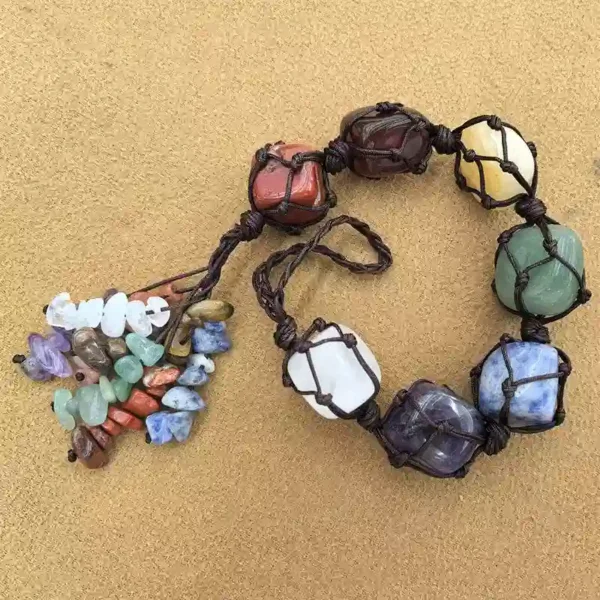 Handmade Macrame Chakra Stones pendant on beige background, 7 chakra crystals with braided cord