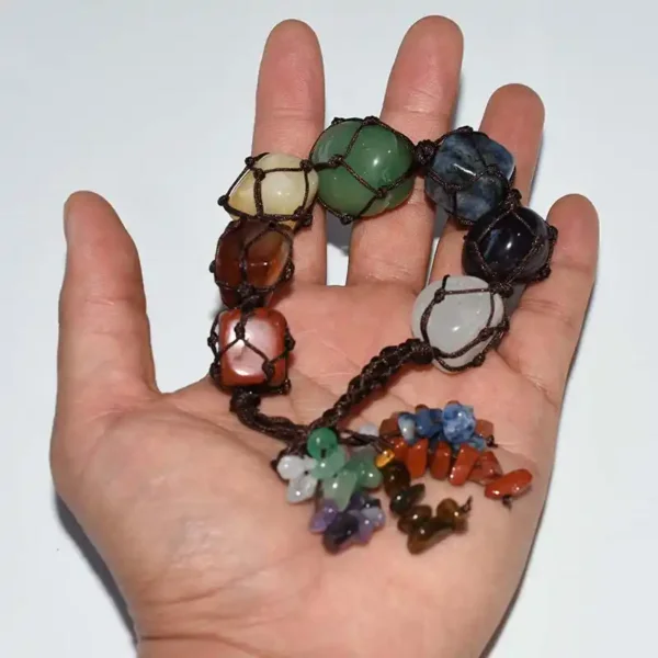 Macrame Chakra Stones shown in hand for scale—seven 2–3 cm stones with braided cord and chip tassel