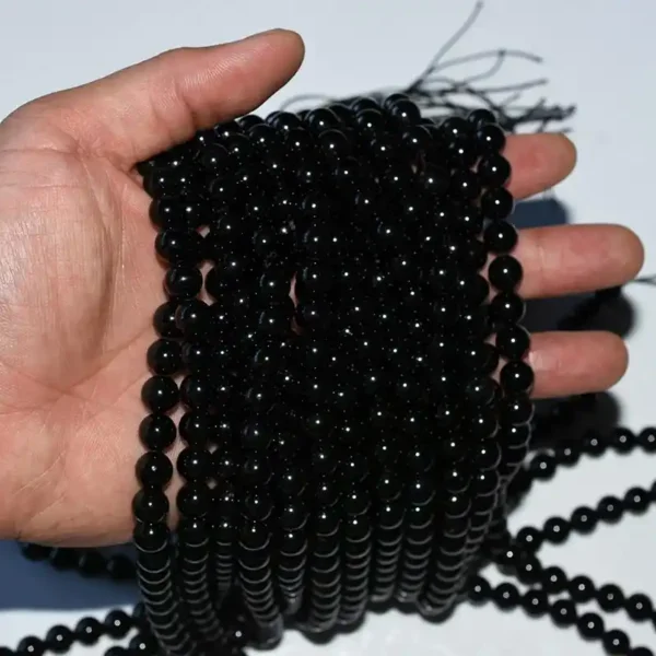 Close-up of Genuine Black Tourmaline Beads strands in hand