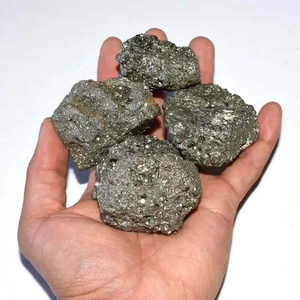 Hand holding raw pyrite cluster, size reference 3-5cm raw pyrite stone