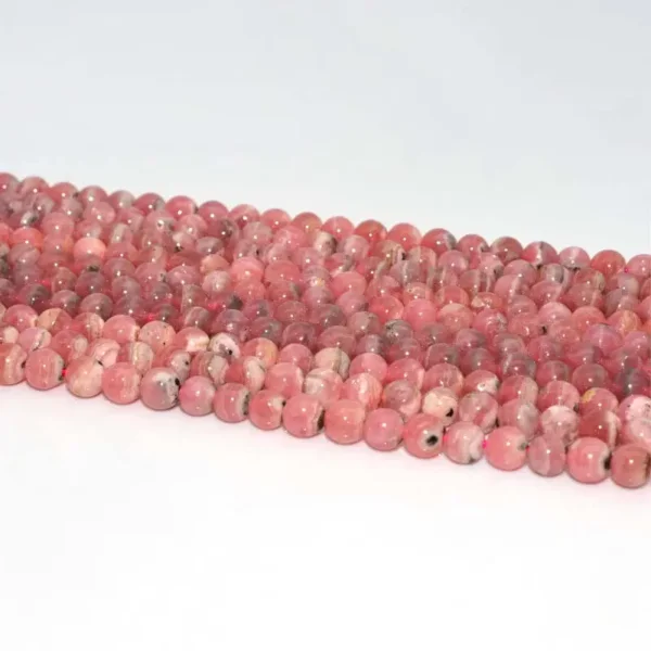 Rhodochrosite Beads 6mm strands on white background, natural pink red stone