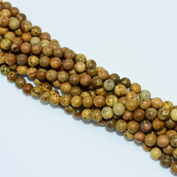 Close-up of polished Picture Jasper Beads with scenic patterns.