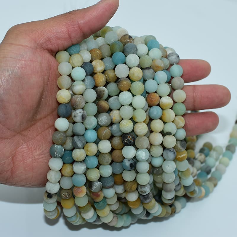 8mm Rainbow Matte Amazonite Beads held in hand displaying multicolor blue, green, and brown shades
