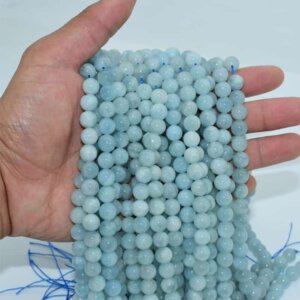 Natural Aquamarine Beads on hand demonstrating light reflection and luster
