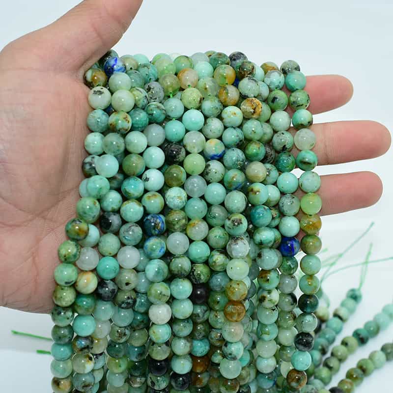 Azurite Chrysocolla Beads held in hand, natural gemstone strands ideal for jewelry crafting